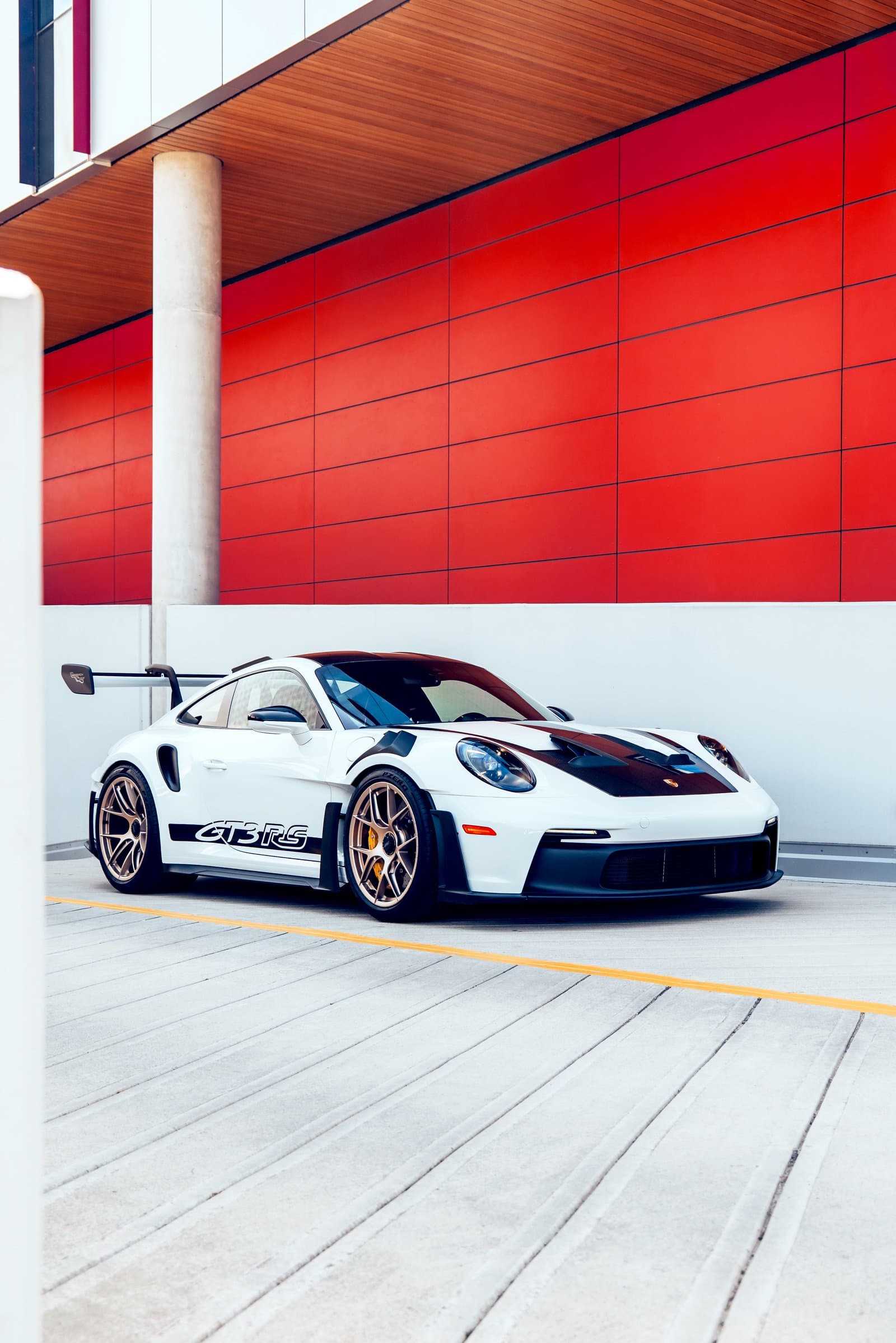 Porsche 911 GT3 RS in white against a red architectural wall
