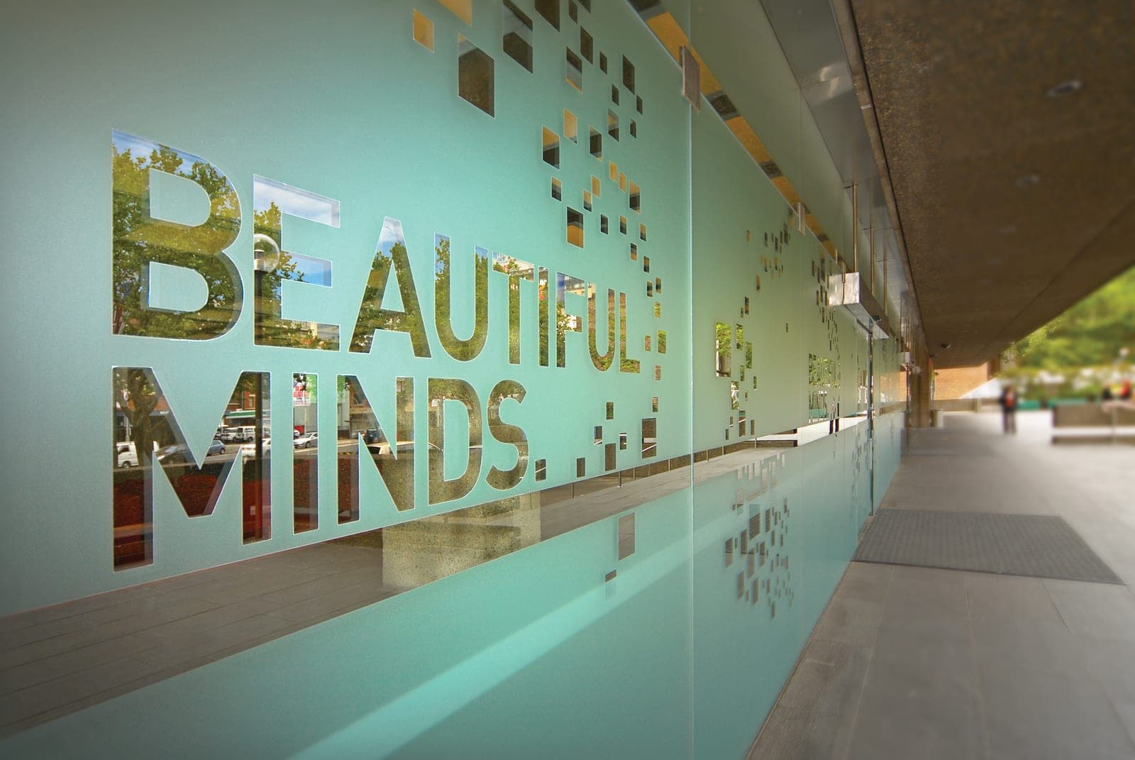 Glass facade with a cut-vinyl 'Beautiful Minds' graphic in frosted film