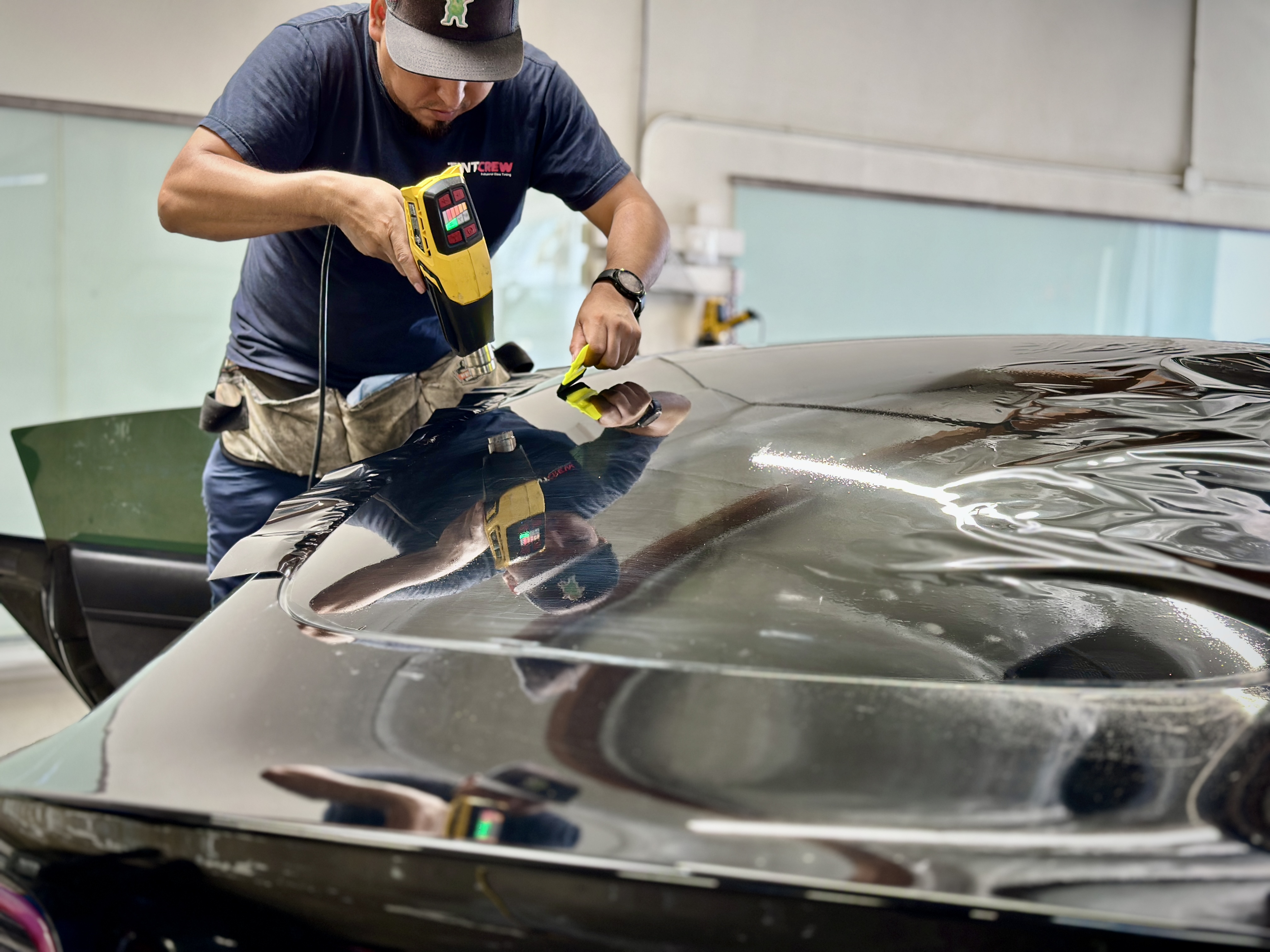 Tint Crew technician installing film on a rear back window
