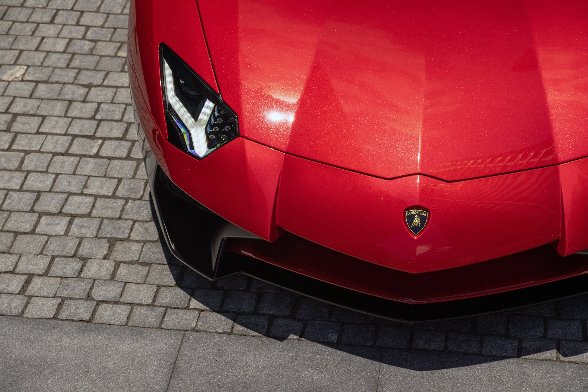 Red Lamborghini front end on cobblestone — protected with Llumar Valor ceramic-infused PPF